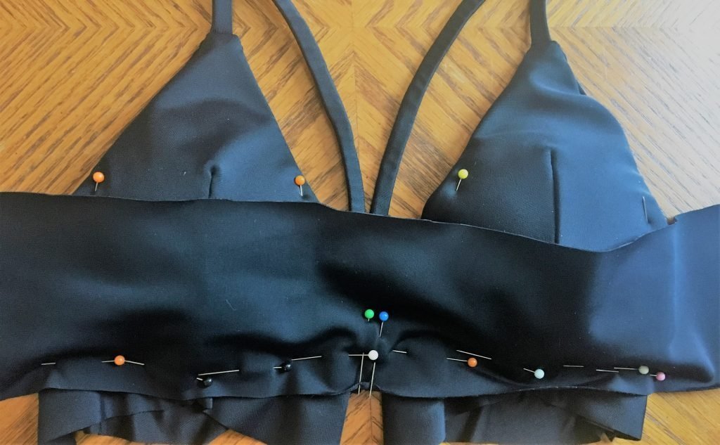 Process of pinning chest strap fabric to triangle bikini top